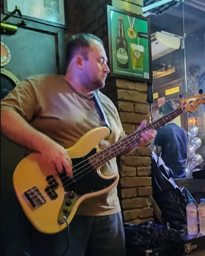 Denis Schell, baixista da OABoys, tocando contrabaixo em show