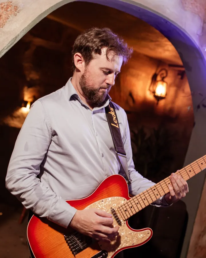 Fabiano Faes Binho, guitarrista da OABoys, tocando guitarra no palco