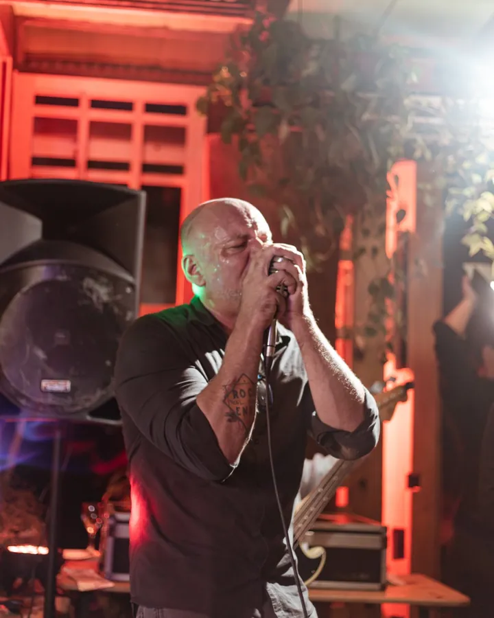Luiz Fernando Cunha, vocalista da OABoys, cantando ao microfone durante show